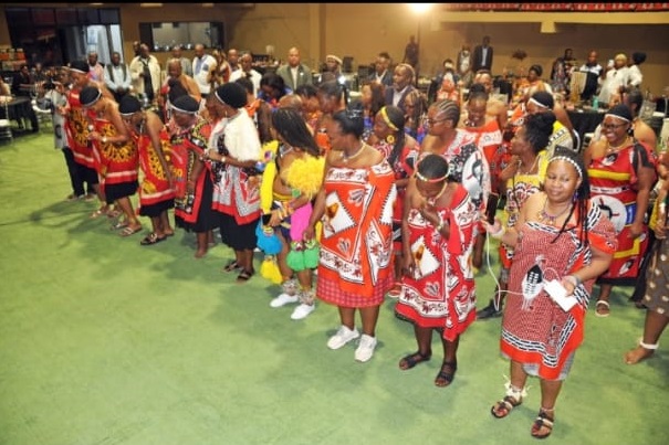 Young people participating in a cultural programme with community leaders present